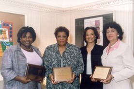 The four female leaders of the Partnership for Reducing the Risk of SIDS in African American Communities initiative stand together. Three of the four are holding plaques.