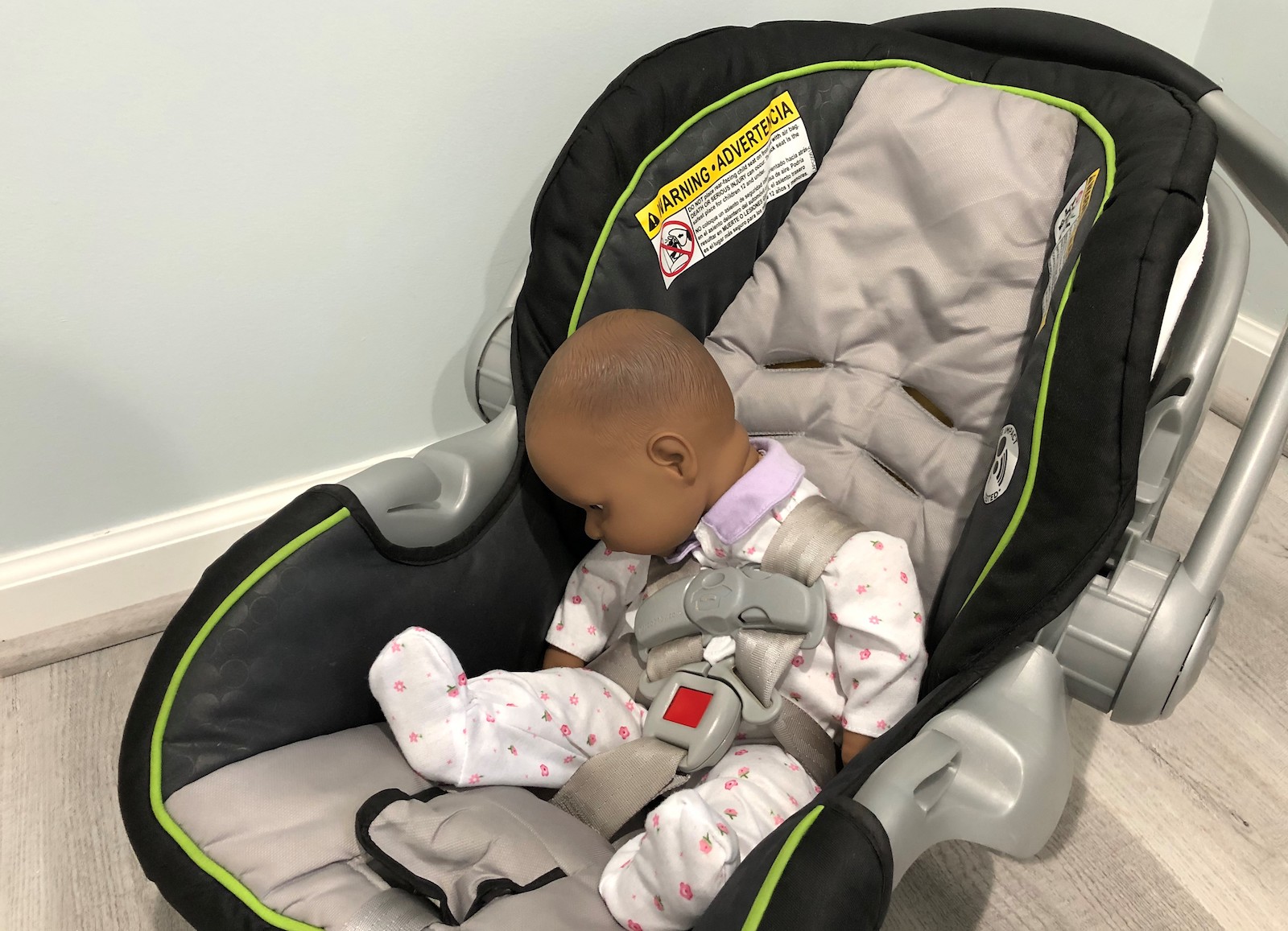 A baby sits in a car seat, with its head towards its chest, which can cause positional asphyxia: a blockage of the infant's airway.